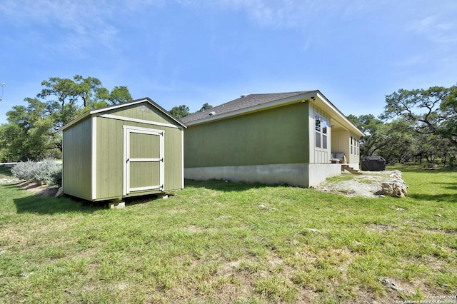 view of side of property featuring a yard and a storage shed