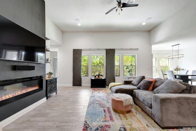 living room with light hardwood / wood-style flooring and ceiling fan