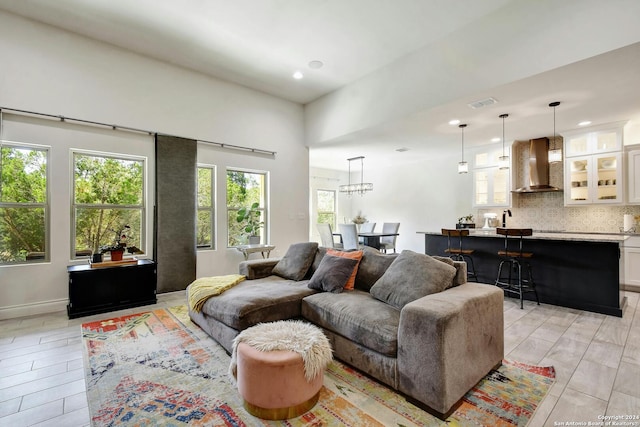 living area with light wood-style floors, visible vents, and recessed lighting