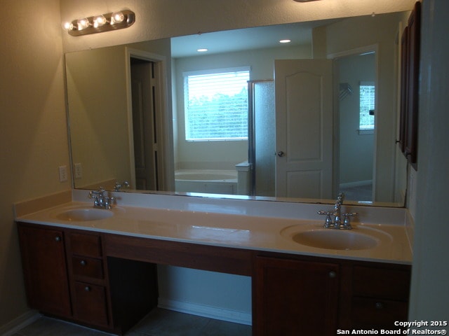 bathroom featuring tile patterned flooring, vanity, toilet, and a bathing tub