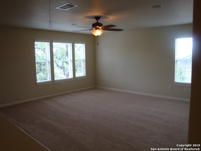 carpeted spare room featuring a textured ceiling and ceiling fan