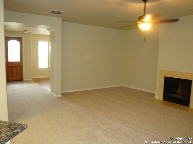 unfurnished living room featuring light colored carpet and ceiling fan