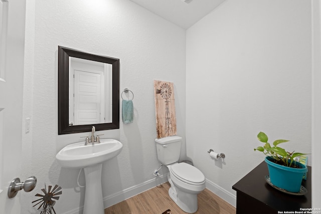 bathroom with lofted ceiling, wood-type flooring, and toilet