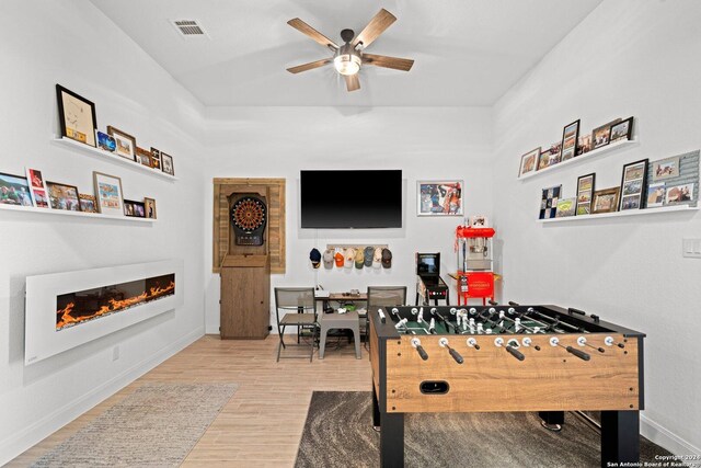 rec room with ceiling fan and light hardwood / wood-style floors