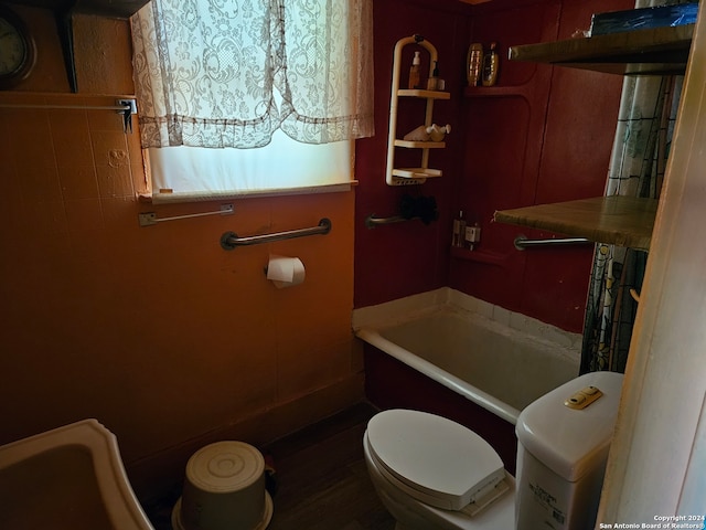 bathroom with wood-type flooring, toilet, and a bathing tub