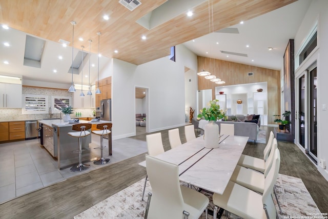 dining room with recessed lighting, visible vents, light wood finished floors, and high vaulted ceiling