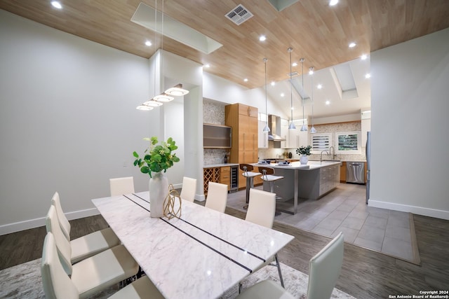 dining area with visible vents, high vaulted ceiling, beverage cooler, wooden ceiling, and baseboards