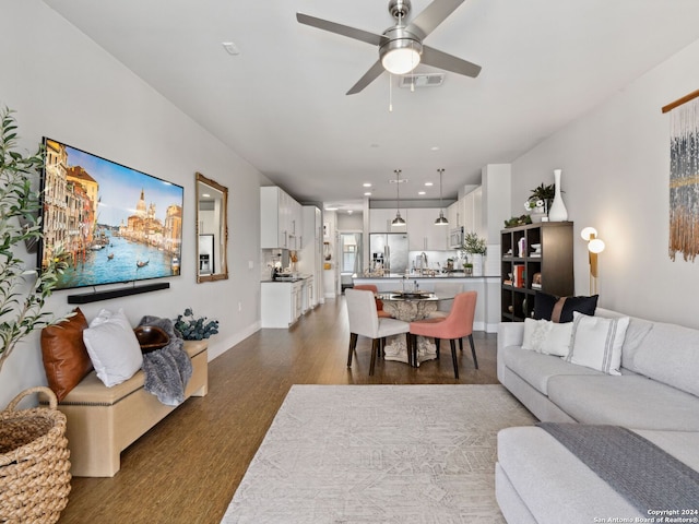 living room featuring ceiling fan and hardwood / wood-style flooring