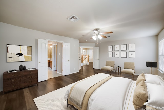 bedroom with dark wood-type flooring, ceiling fan, and ensuite bath