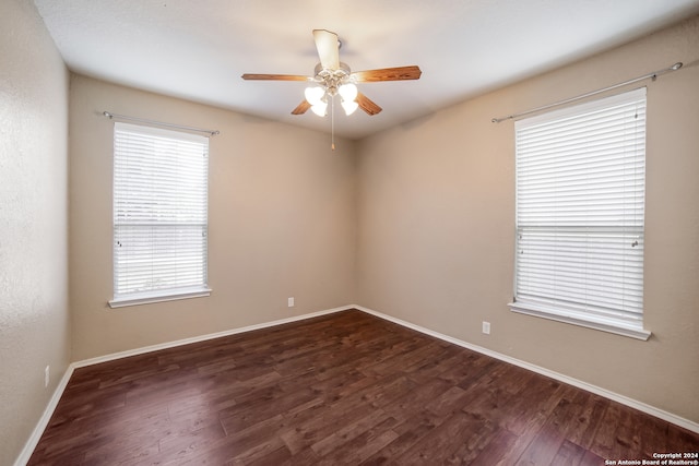 unfurnished room with dark hardwood / wood-style floors, ceiling fan, and a wealth of natural light