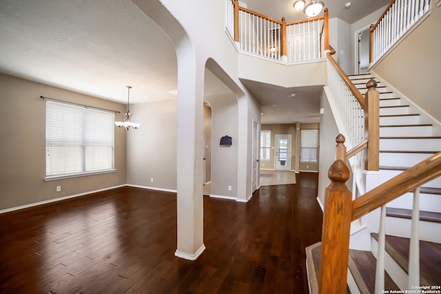 entryway featuring an inviting chandelier and dark wood-type flooring