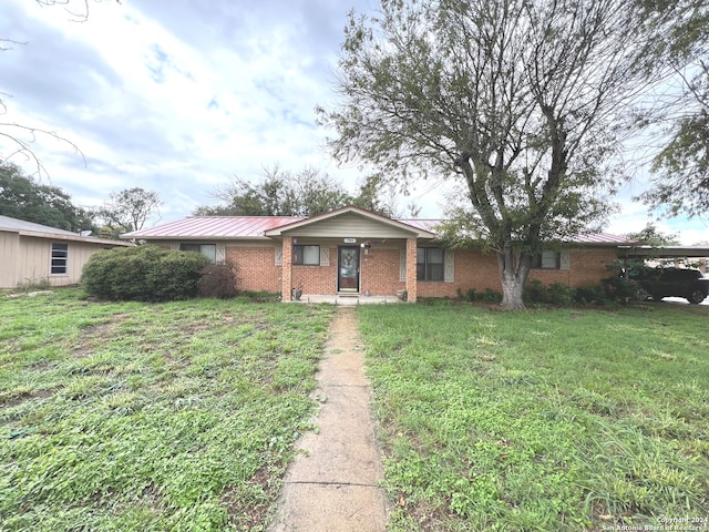 single story home featuring a front lawn and a carport