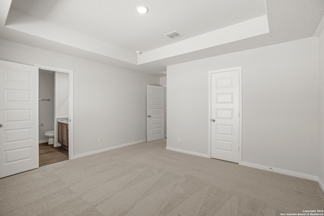 15055 Homing Mdw, San Antonio, TX 78253 - unfurnished bedroom with a tray ceiling, light carpet, baseboards, ensuite bath, and recessed lighting