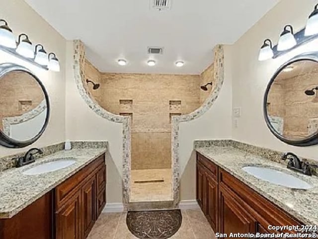 bathroom featuring vanity, tile patterned floors, and tiled shower