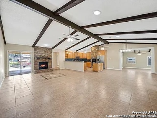 unfurnished living room with vaulted ceiling with beams, a stone fireplace, light tile patterned flooring, and ceiling fan