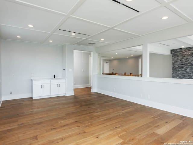 unfurnished living room featuring light hardwood / wood-style floors and coffered ceiling