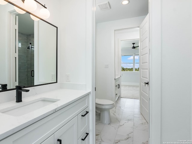 bathroom with ceiling fan, toilet, an enclosed shower, and vanity