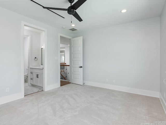 unfurnished bedroom with ensuite bathroom, ceiling fan, and light colored carpet