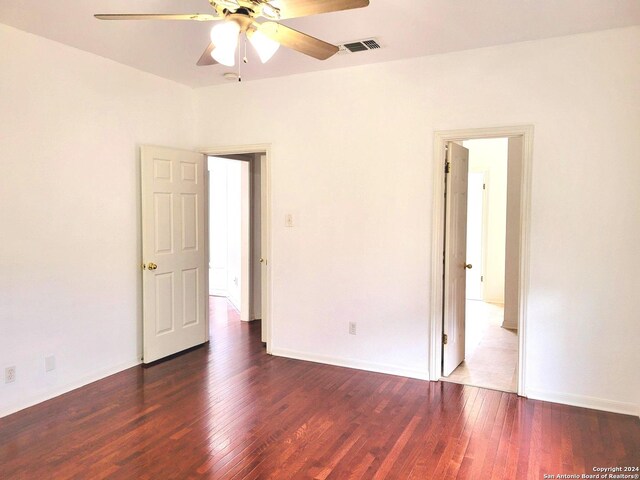 unfurnished bedroom with dark wood-type flooring and ceiling fan