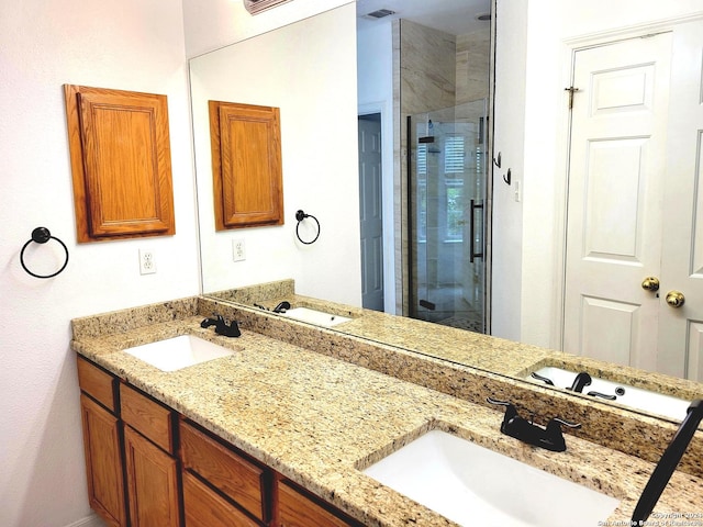 bathroom with vanity and a shower with shower door