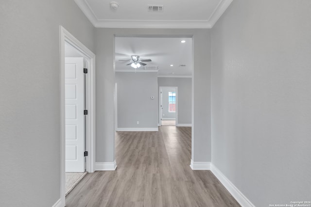 hallway featuring ornamental molding and light wood-type flooring