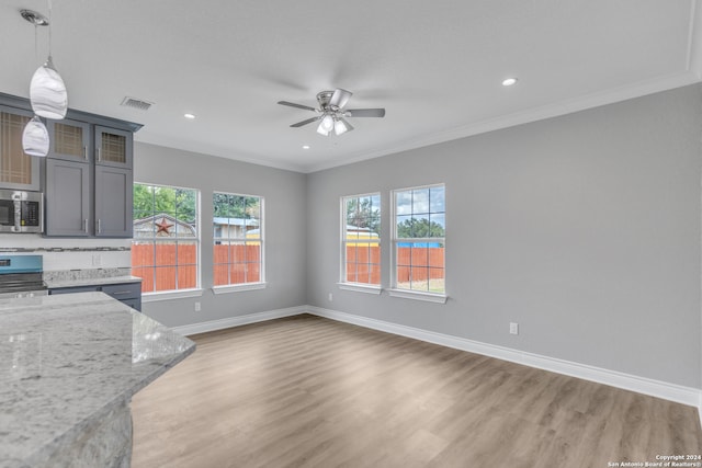 kitchen featuring pendant lighting, hardwood / wood-style floors, appliances with stainless steel finishes, ornamental molding, and ceiling fan