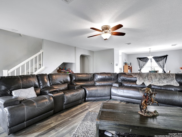 living room with ceiling fan, dark hardwood / wood-style floors, and a textured ceiling