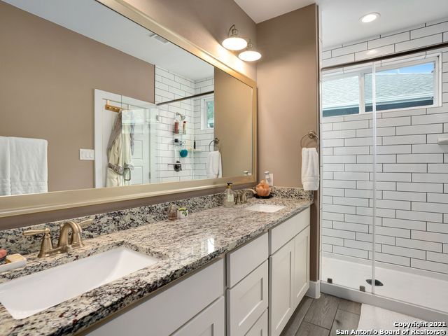 bathroom with vanity, hardwood / wood-style flooring, and a shower with door