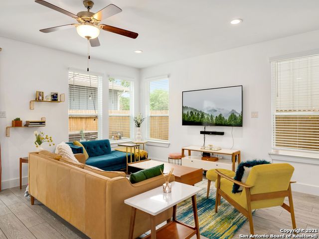 living room featuring light wood-type flooring and ceiling fan