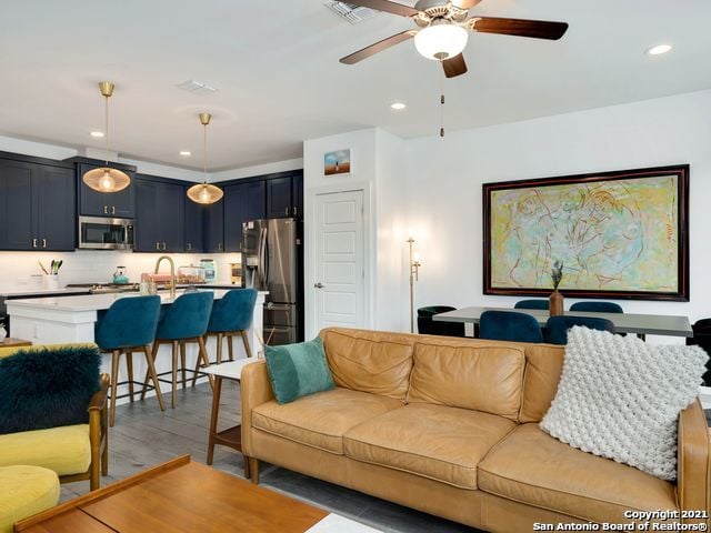 living room with ceiling fan and hardwood / wood-style floors