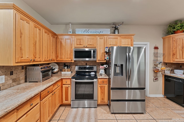 kitchen featuring appliances with stainless steel finishes, light stone counters, light tile patterned floors, and decorative backsplash