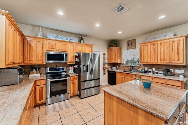 kitchen with light tile patterned floors, a kitchen island, stainless steel appliances, and decorative backsplash