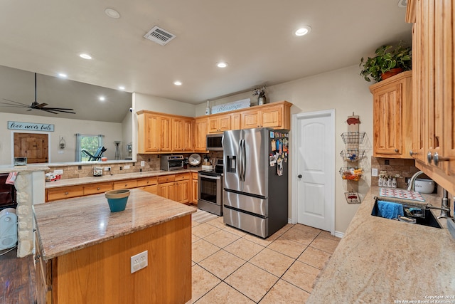 kitchen featuring light tile patterned floors, backsplash, appliances with stainless steel finishes, kitchen peninsula, and ceiling fan