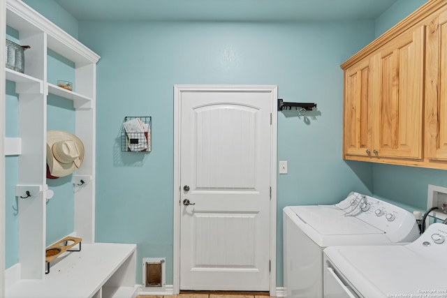 laundry room with washing machine and clothes dryer and cabinets