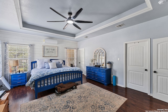 bedroom featuring dark hardwood / wood-style flooring, a tray ceiling, wood walls, ceiling fan, and an AC wall unit