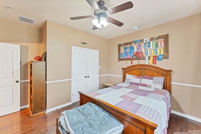 bedroom with dark hardwood / wood-style flooring, ceiling fan, and a closet