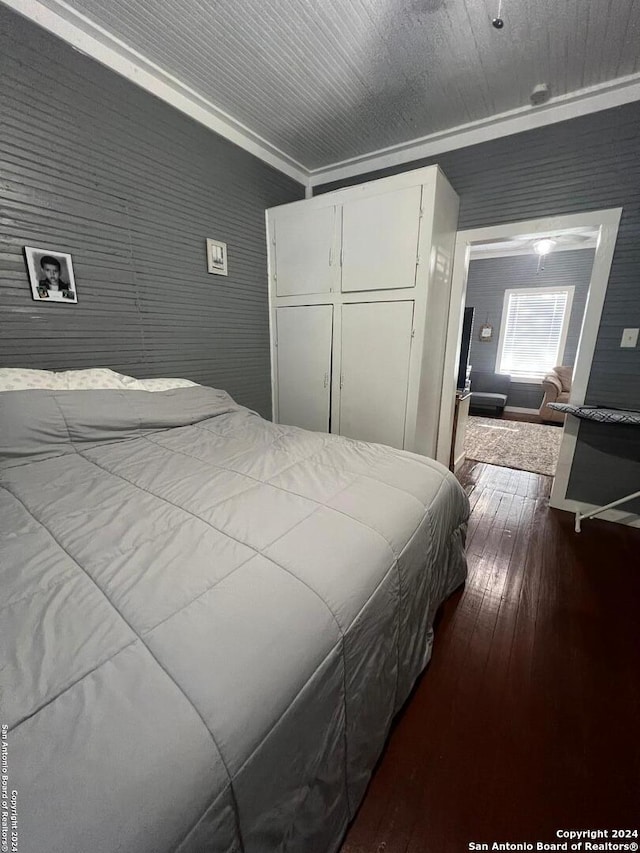 bedroom with hardwood / wood-style floors, a closet, and crown molding