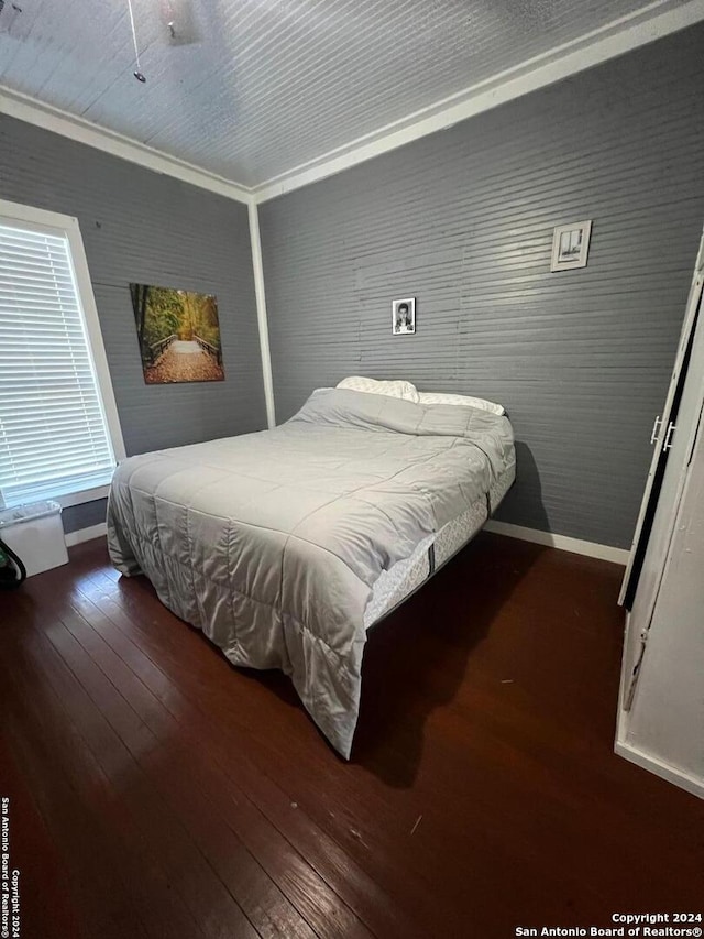 bedroom with dark hardwood / wood-style floors and crown molding