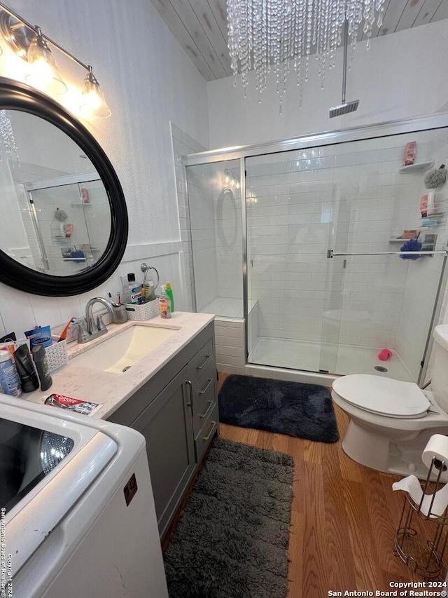 bathroom featuring vanity, toilet, hardwood / wood-style floors, and a shower with door