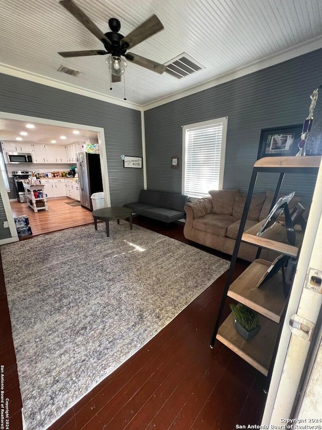 living room with crown molding, ceiling fan, and dark hardwood / wood-style floors