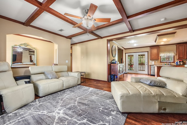 living room with beamed ceiling, coffered ceiling, wood-type flooring, ceiling fan, and ornamental molding