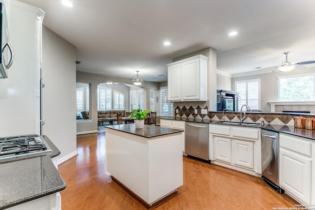 kitchen with a center island, tasteful backsplash, appliances with stainless steel finishes, open floor plan, and a sink