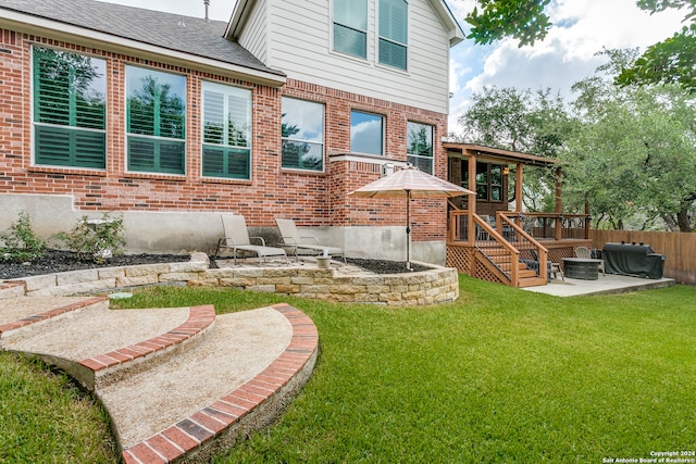 back of property featuring a patio area, a yard, and a wooden deck