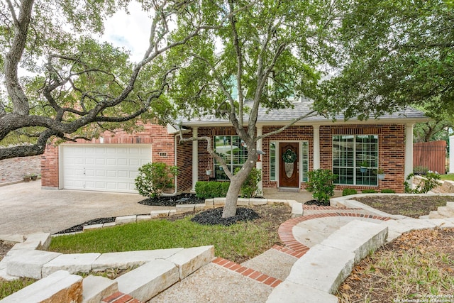 ranch-style house featuring a shingled roof, brick siding, driveway, and an attached garage