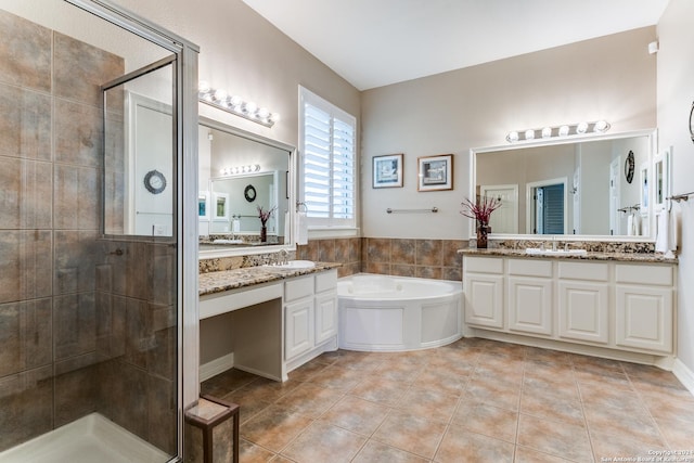 bathroom with a shower stall, a sink, and tile patterned floors