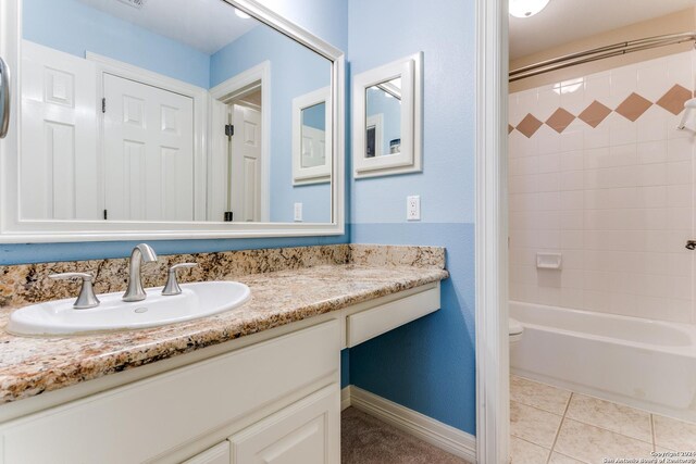 full bathroom featuring tile patterned flooring, vanity, toilet, and tiled shower / bath