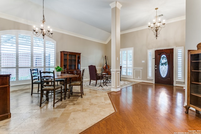 dining space with ornamental molding, an inviting chandelier, hardwood / wood-style flooring, and decorative columns