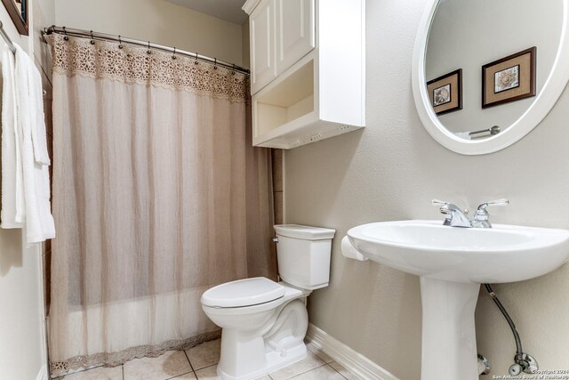 bathroom featuring toilet, a shower with curtain, and tile patterned floors