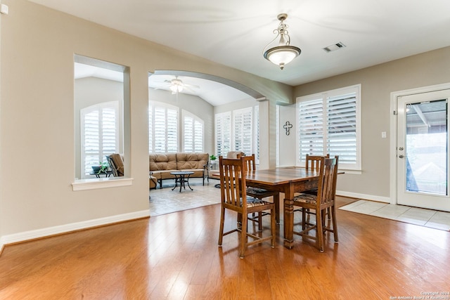 dining room with visible vents, lofted ceiling, light wood-style flooring, and baseboards