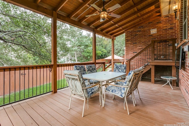 wooden terrace with a ceiling fan and outdoor dining area